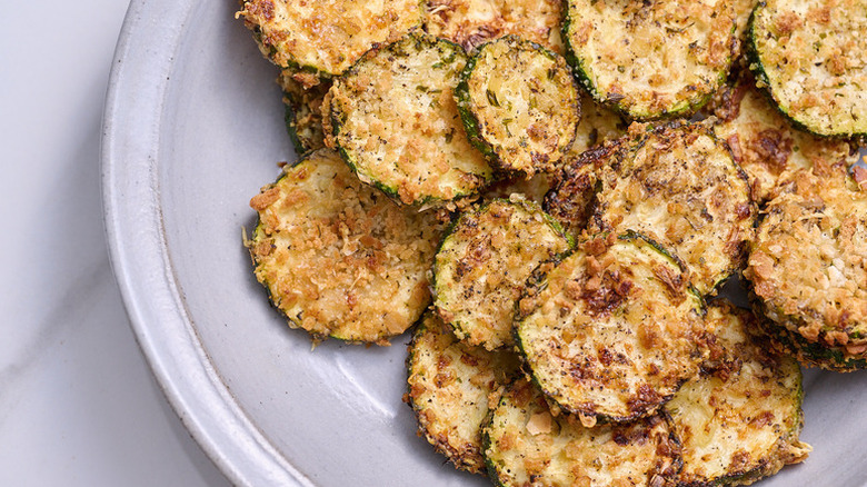 Pile of cheesy zucchini chips on plate