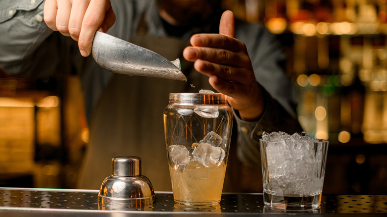 Bartender adding ice to a shaker