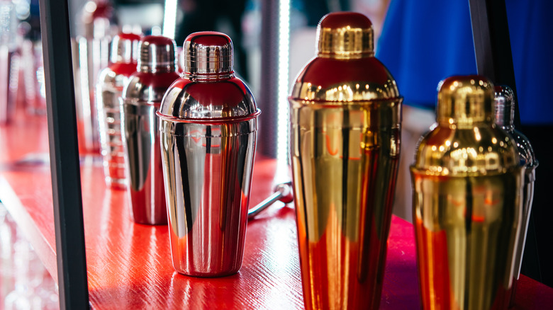 Several cocktail shakers on a bar