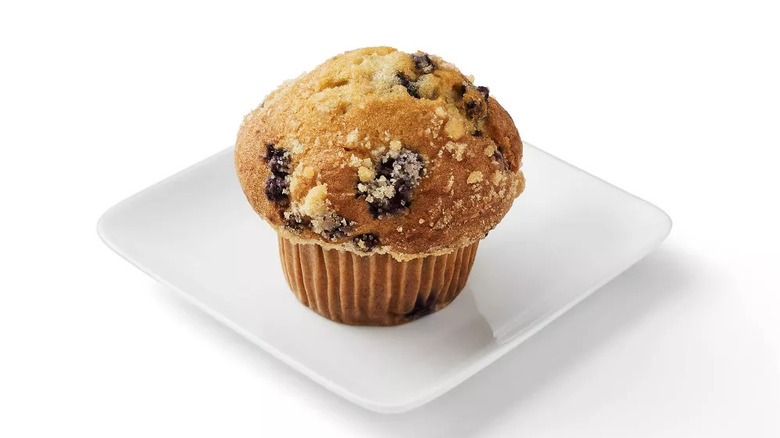 Single blueberry muffin with streusel topping on square white plate