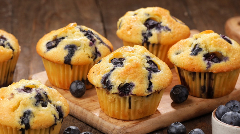 Fluffy, tender blueberry muffins on wooden serving board