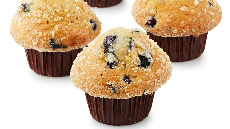 Four blueberry streusel muffins on white background
