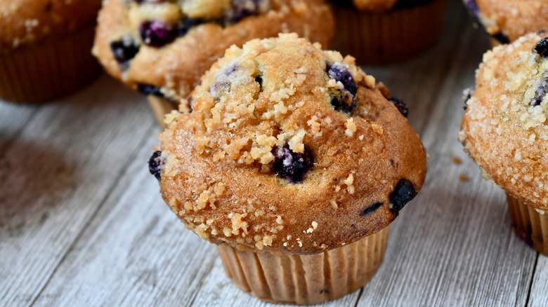 Blueberry streusel muffins on rustic wooden surface