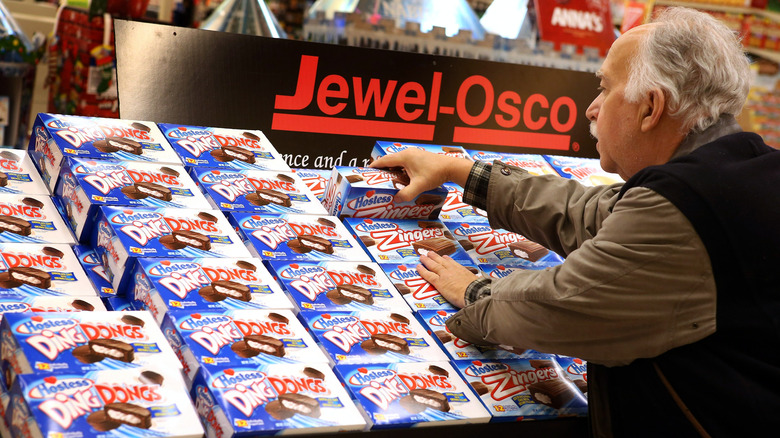 Person at store arranging Hostess boxes of snack cakes