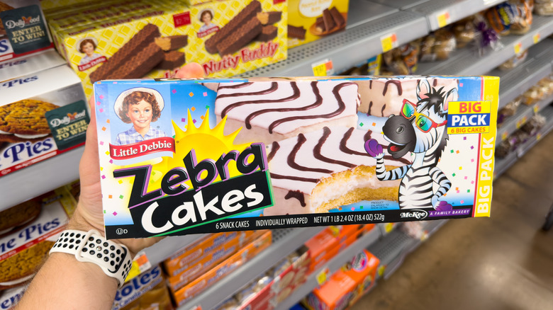 Hand holding box of Little Debbie Zebra Cakes