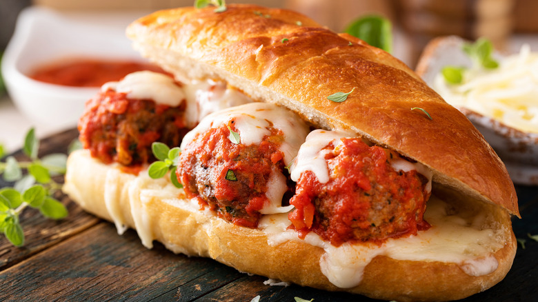 A meatball sandwich with herbs and cheese