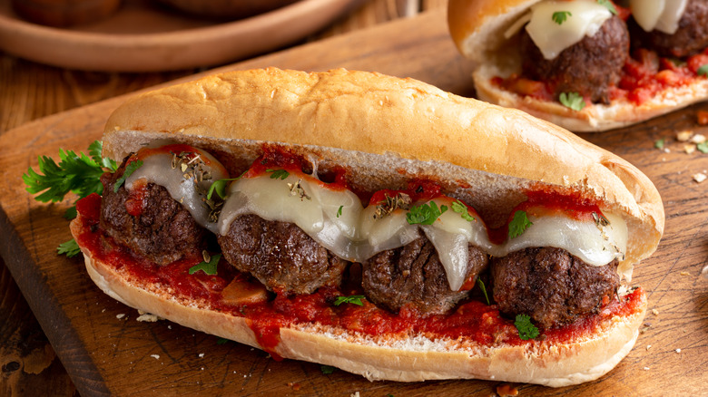 Meatball sub on a board with cheese