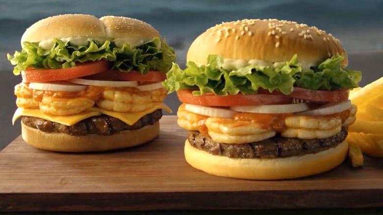 Two Whole Shrimp Whopper burgers from Burger King on brown wooden board