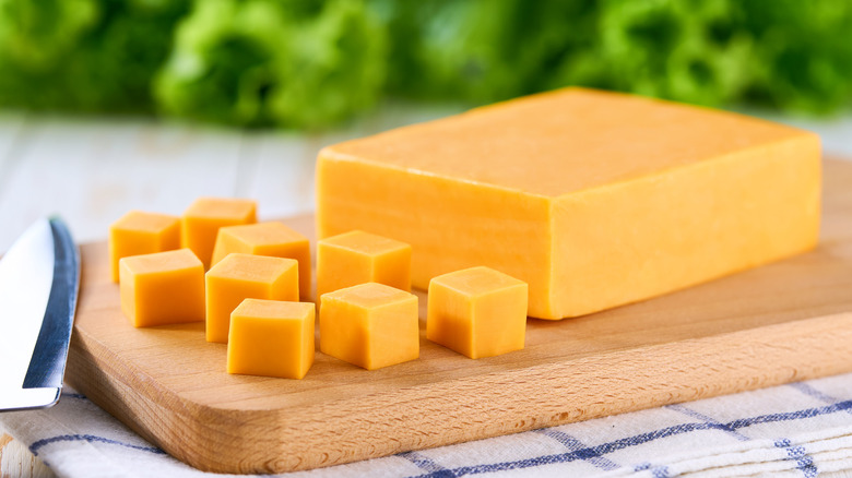 a block of cheddar with some cubes cut off