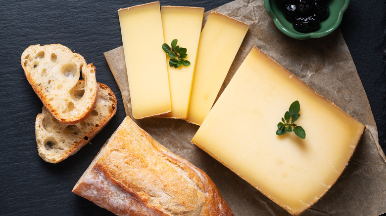 a wedge and sliced Comté cheese with baguette and jam
