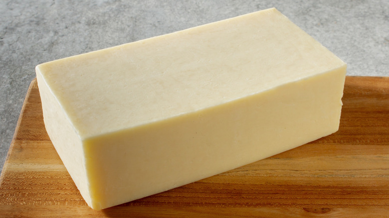 a block of Monterey Jack cheese on a board