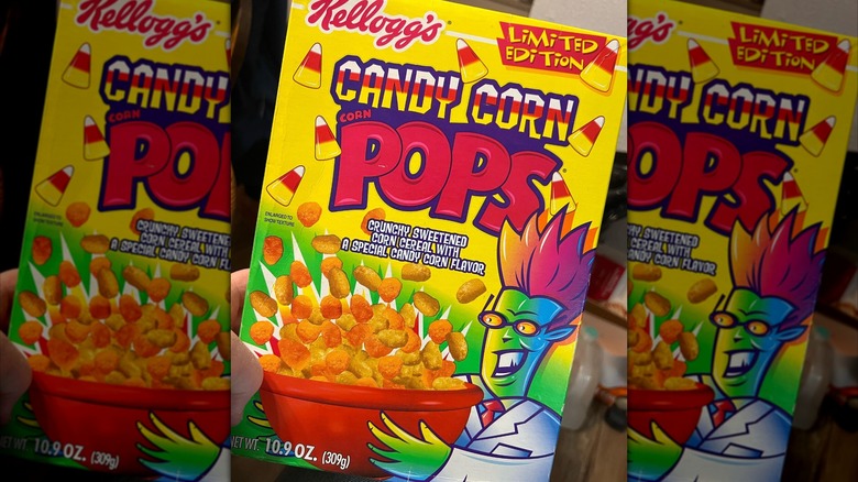 A hand holds a box of Candy Corn Corn Pops.