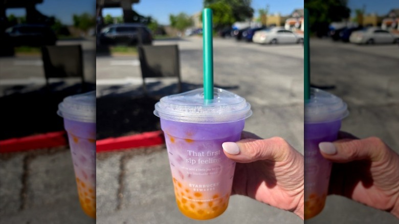 close up of a woman holding a Starbucks Butterfly Drink