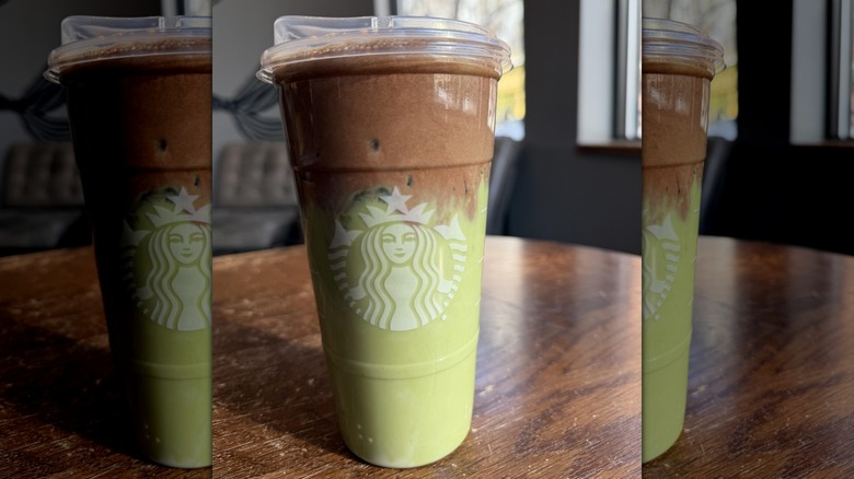 a Starbucks Iced Dubai Chocolate Matcha on wood table
