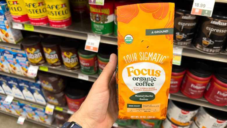 A customer holding Four Sigmatic mushroom coffee package inside store.