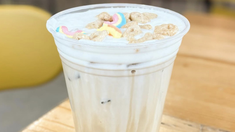 A milky coffee garnished with cereal.