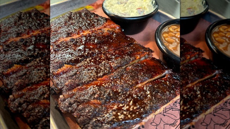 Sliced rack of ribs on tray with sides