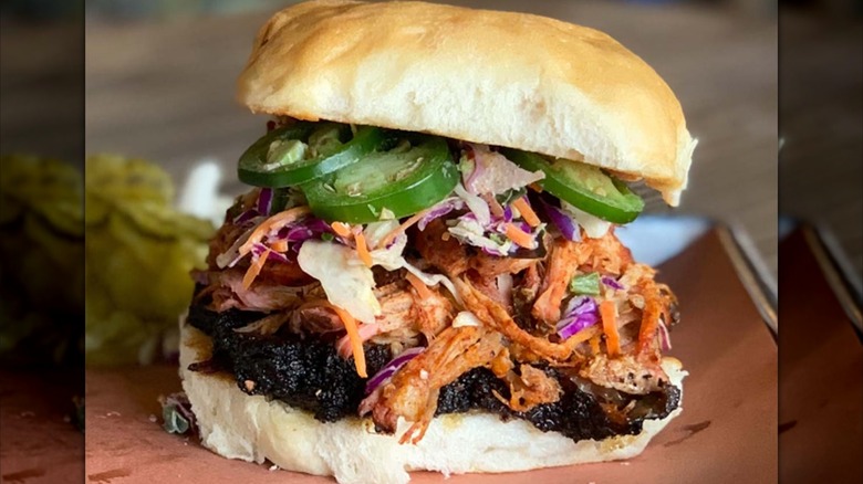 Pitmaster sandwich with meats, coleslaw, and jalapenos