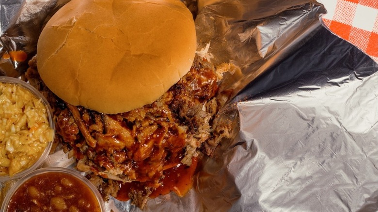 Pulled pork sandwich on foil with sides
