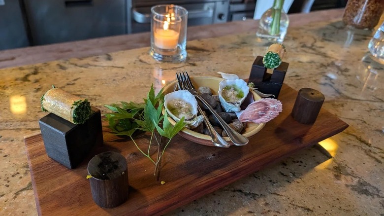 Wooden platter of oysters and canolis from Altura Italian restaurant in Seattle