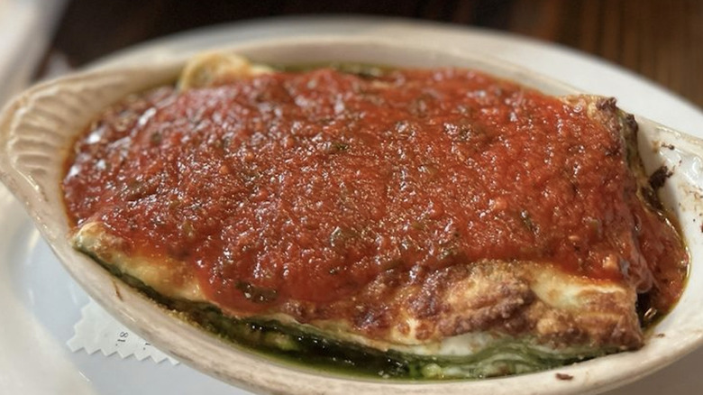 White bowl of lasagna with red sauce on top from The Pink Door in Seattle