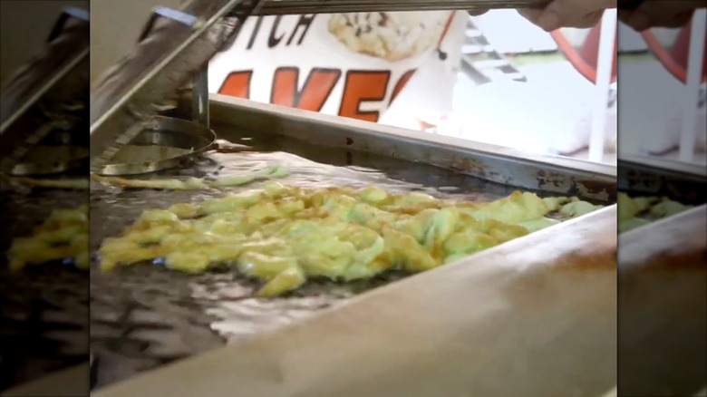 Green Jell-O batter floating in frying oil