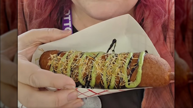 Close-up of hand holding Dubai chocolate corndog