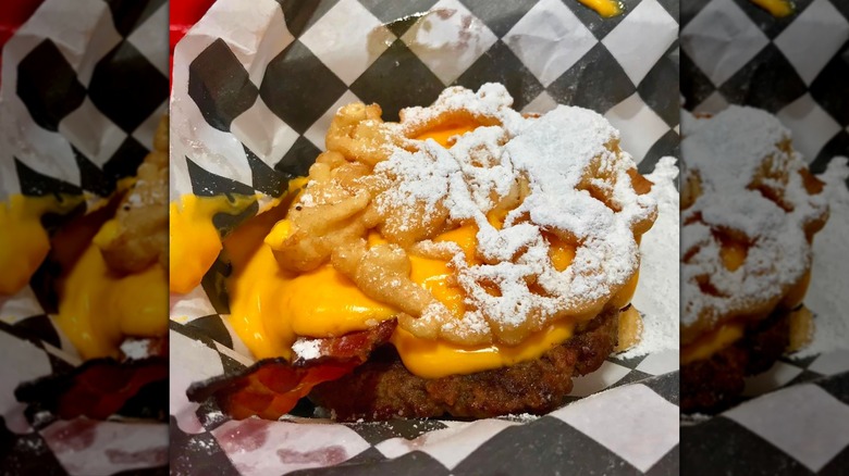 Funnel cake bacon queso burger in checkered paper