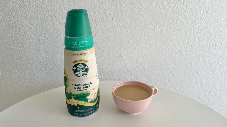 Starbucks Sugar Cookie Latte Non-Dairy Creamer on white table with a pink cup filled with coffee