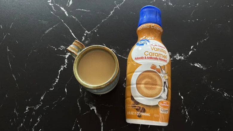 Walmart Great Value Vanilla Caramel Creamer on black marble table with a cup of coffee on the side