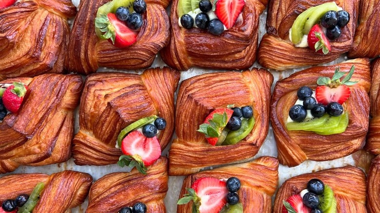 Danish pastries topped with fresh fruits on tray at Auspicious Sandfly