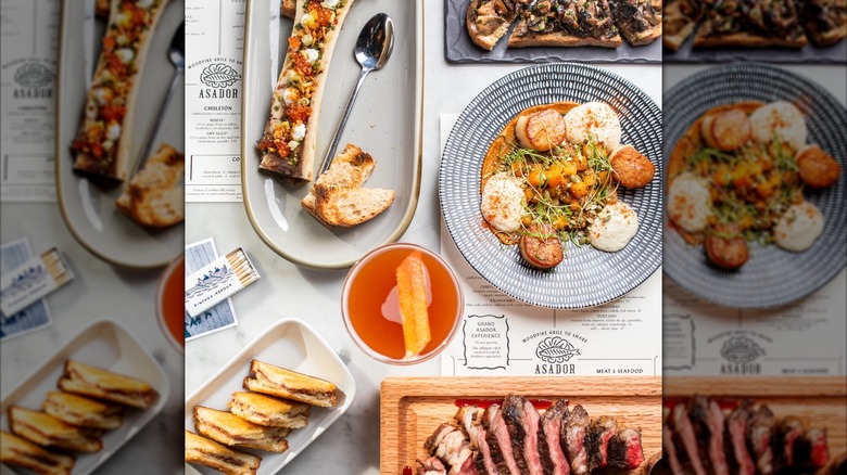 Assortment of dishes including seafood and meat on table with menus