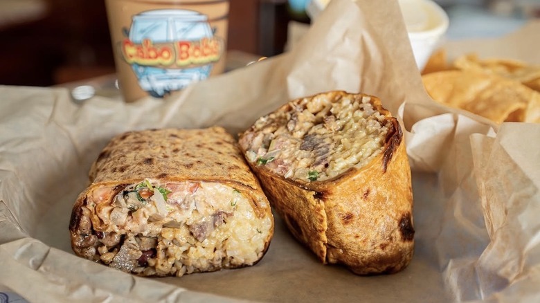 Burrito with tortilla chips and a drink