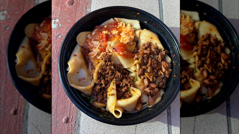 Noodle dish with toppings in a black bowl