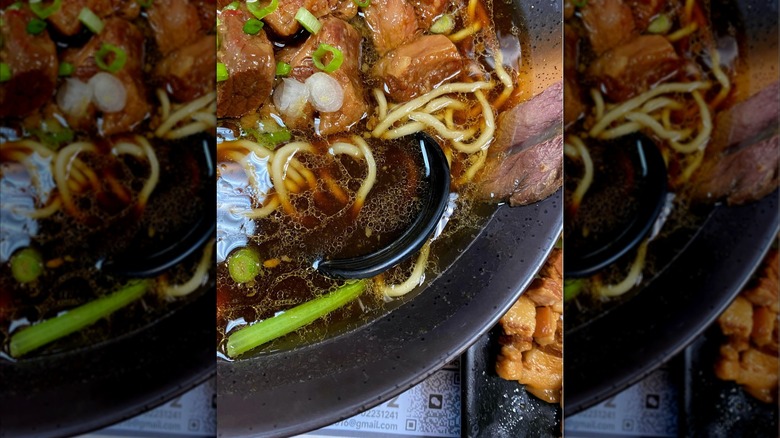 Beef noodle soup in a black bowl from Luyixian