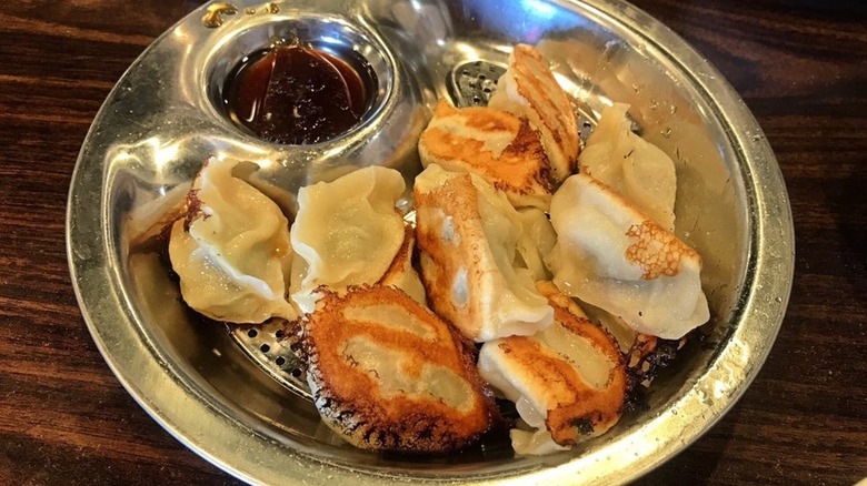 House dumplings in a metal bowl with dipping sauce