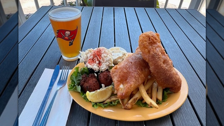 Fish 'n' chips plate with fries, hushpuppies, slaw on yellow plate