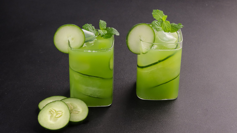 Two glasses of cucumber juice garnished with mint and cucumber slices