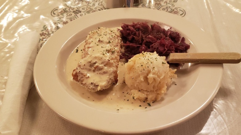 Schnitzel and gravy on plate with mashed potatoes