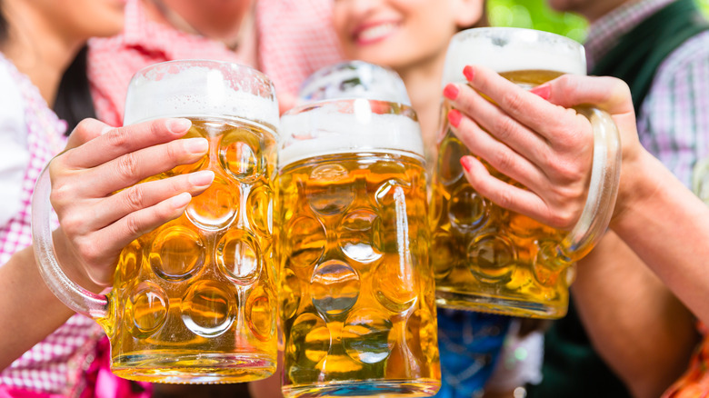 Traditional glasses of beer with people blurred in background