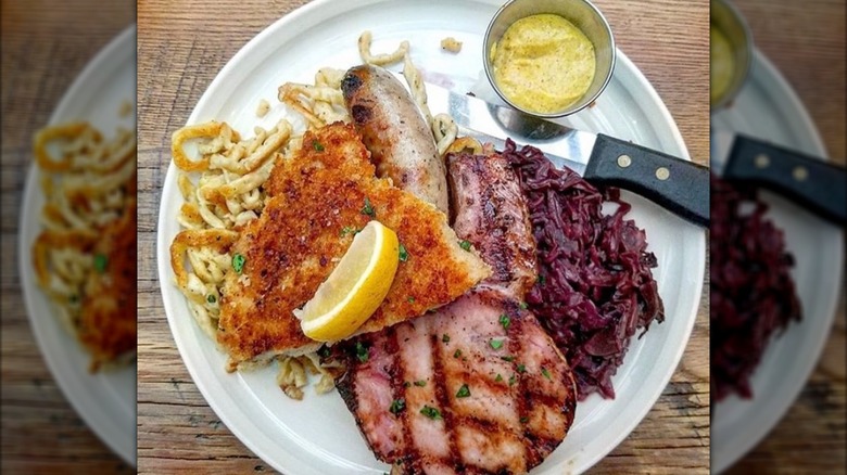Sampler platter with schnitzel, spaetzle, sausage, cabbage, and mustard