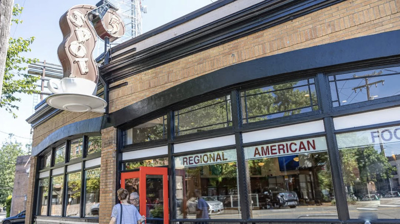 The exterior of 5 Spot, Seattle, with a large neon coffee cup sign