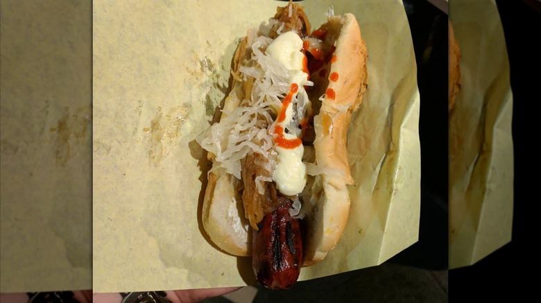 person holding Seattle hot dog from Monster Dogs