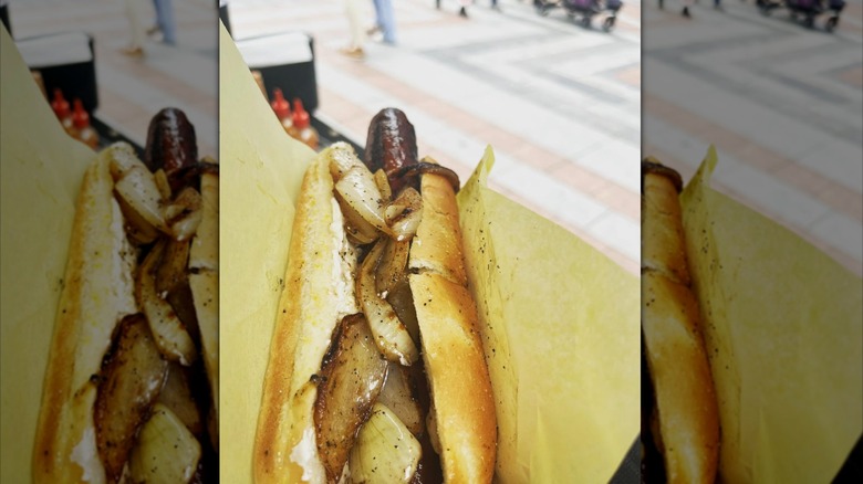 person holding a Seattle hot dog from Nola Dogs