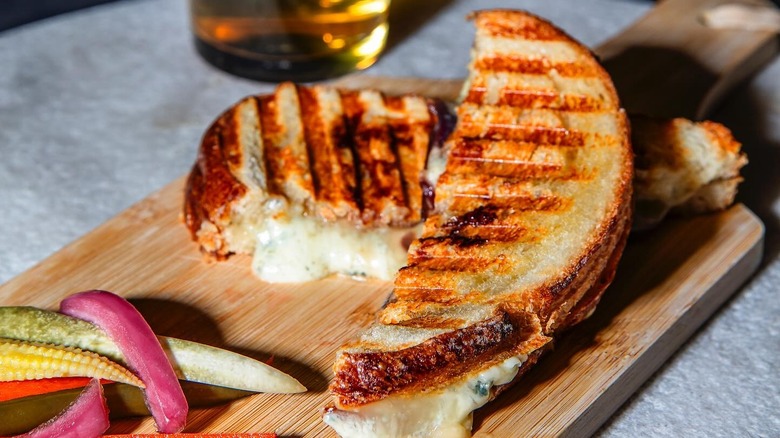 Sliced grilled cheese sandwich on wooden board