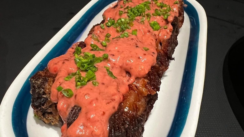 Plate of veal bacon with red wine mustard sauce