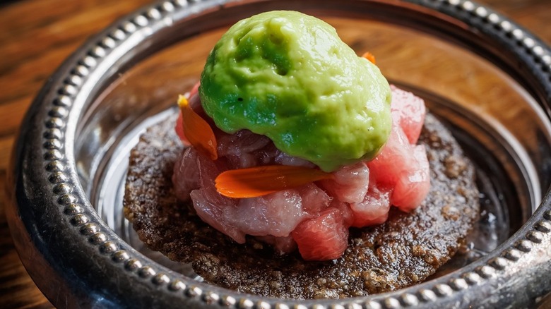 Tiny tuna belly tostada topped with avocado sauce