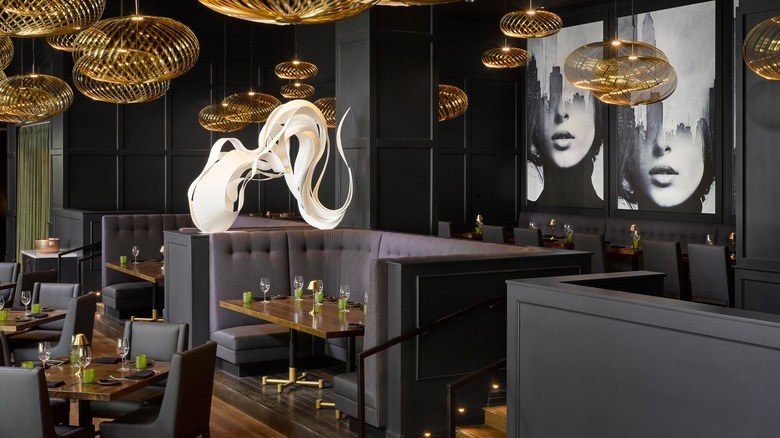 Americano Atlanta's dinign room with gray booths and golden light fixtures