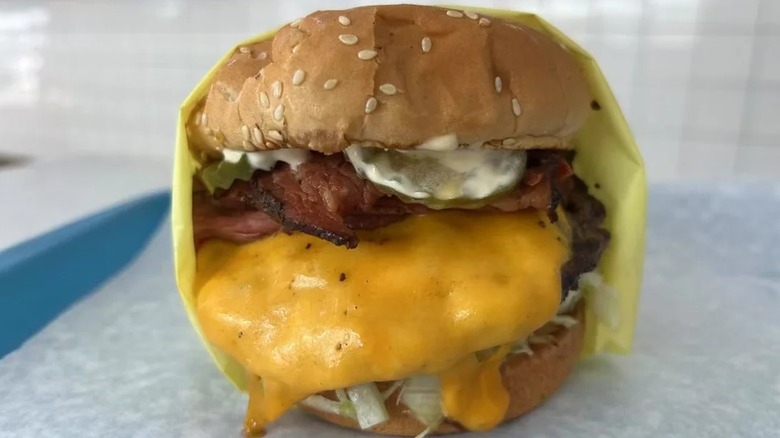 Burger with cheese, pastrami, and pickles