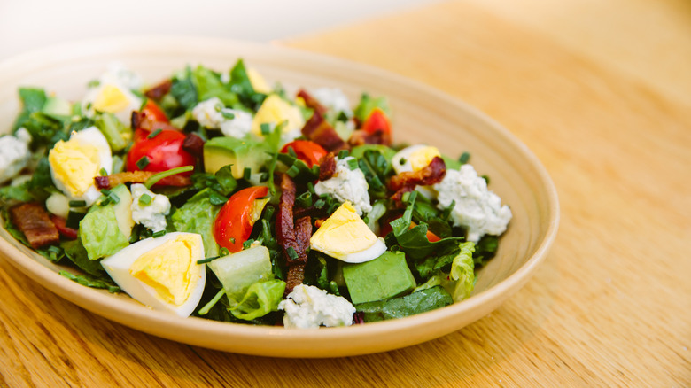 Cobb salad with romaine, bacon, egg, avocado, and blue cheese